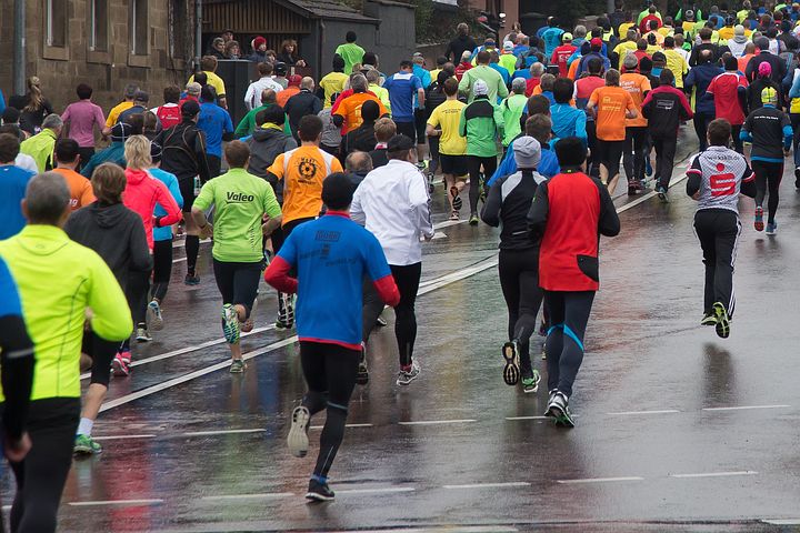 Large group of runners taking part in a marathon on rainy day